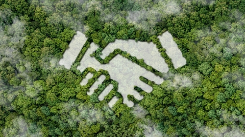 Image of hands shaking cut out of tree tops